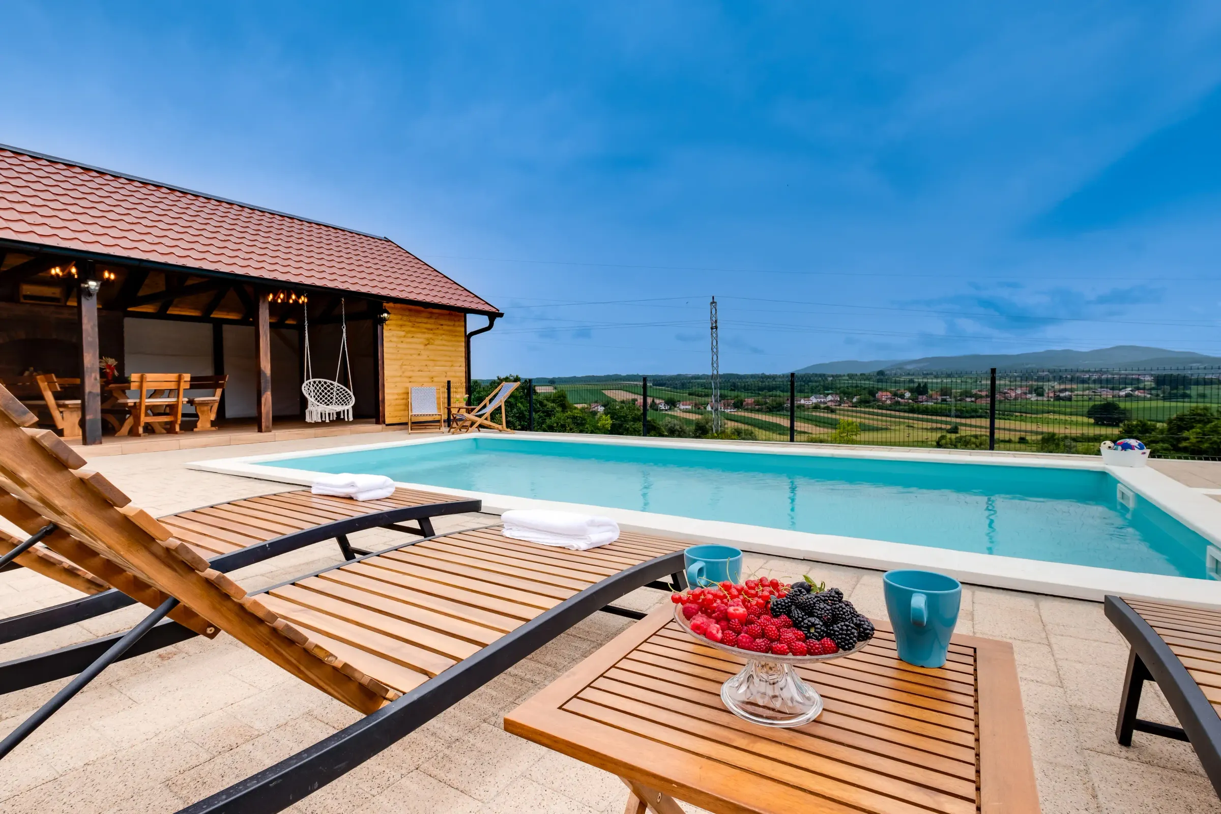 Pool und überdachte Terrasse in der Abenddämmerung, mit warmem Licht
