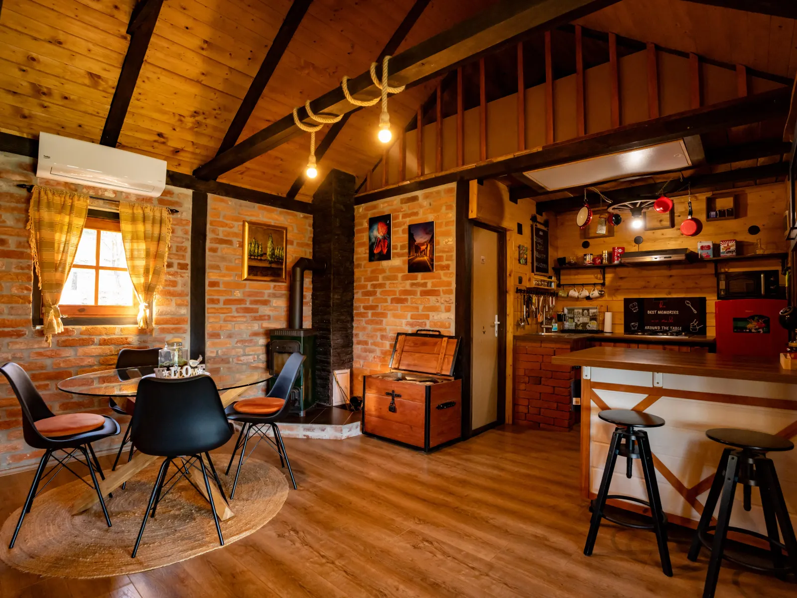Wohnzimmer mit Küche, Ziegelwänden und Holzofen