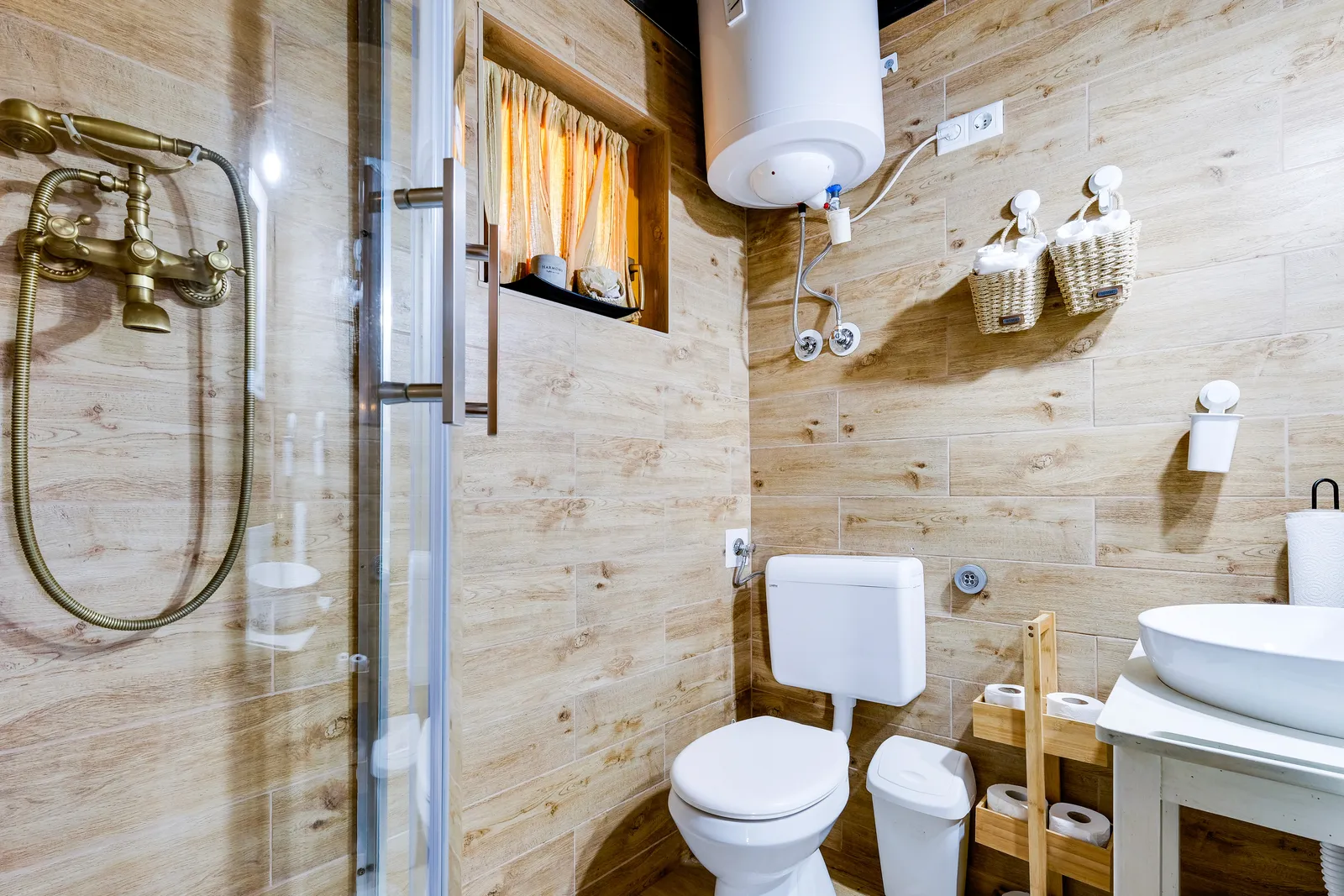 Badezimmer mit Duschkabine, Waschbecken und Fliesen in Holzoptik